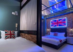 two beds in a room with british flags on the wall at Time Light Walk B&B in Hualien City