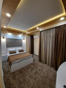 a large bedroom with a large bed and curtains at Hotel Juliet Yerevan in Yerevan