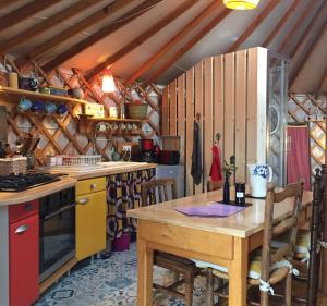 a kitchen with a wooden table and a stove at La Yourte in Moussages