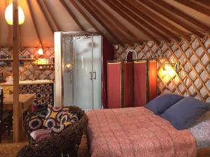 een slaapkamer in een yurt met een bed en stoelen bij La Yourte in Moussages