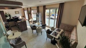 a living room with tables and chairs and a kitchen at Hotel Glorija in Međugorje