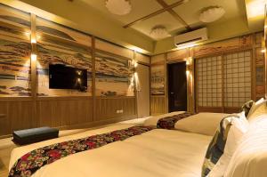 a hotel room with two beds and a flat screen tv at Time Light Walk B&B in Hualien City