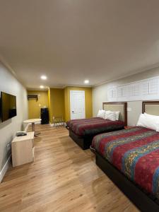 Cette chambre comprend 2 lits et une table. dans l'établissement Ritz Inn-San Francisco Airport SFO, à San Bruno
