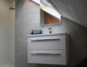 W łazience znajduje się biała umywalka i lustro. w obiekcie La maison du pêcheur Koksijde w mieście Koksijde