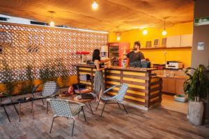 a man and a woman standing at a counter at Distrito Hostel in Santa Marta