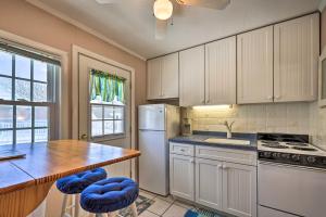 a kitchen with white cabinets and a kitchen island with blue stools at Cape Cod Retreat with Gas Grill Steps to Beach in Dennis Port