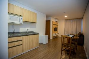 a small kitchen with a table and a microwave at Tri Hotel Chapecó in Chapecó