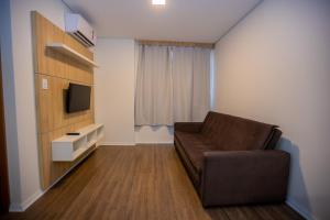 a living room with a couch and a television at Tri Hotel Chapecó in Chapecó