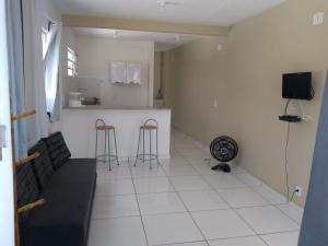 阿拉亚尔-杜卡布Acomodações Araujo的客厅里有一张沙发和一个厨房