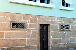 a brick building with a black door and two windows at BABhouse Casa da Mata - Coração do Douro in Nagoselo do Douro