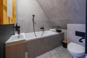 a bathroom with a bath tub and a toilet at Nase Chaty- domki z balią, termy i natura in Biały Dunajec +29 photos