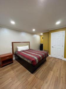 um quarto com uma cama e piso em madeira em Ritz Inn-San Francisco Airport SFO em San Bruno