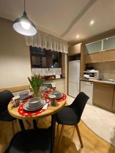 uma cozinha com mesa e cadeiras e uma cozinha com frigorífico em Apartament Kryjówka pod Giewontem em Kościelisko