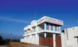 a white building with a sign on top of it at Green Apple Resorts in Yelagiri