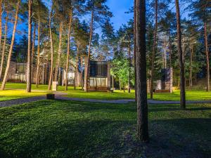 ein Haus inmitten eines Parks mit Bäumen in der Unterkunft TonyResort in Trakai