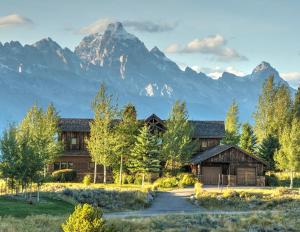a log home with mountains in the background at Spring Creek Ranch in Jackson