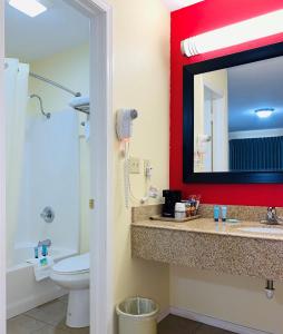 a bathroom with a toilet and a sink with a mirror at Suite 16 Motel in Gore