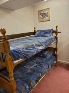 a bed with a wooden frame in a room at Bowering Lodge in Blue Mountains