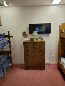 a bedroom with a tv and a dresser with a lamp at Bowering Lodge in Blue Mountains