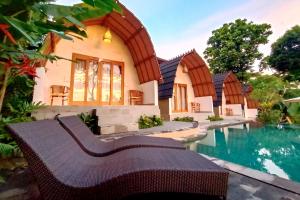 a house with a swimming pool in front of a house at Uma Manyar Sunset Villa in Ubud