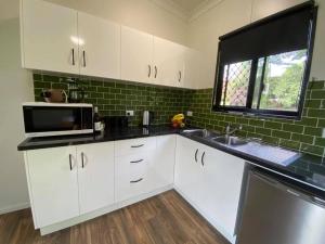 a kitchen with a stove top oven and a sink at Mena Creek Flower House in Mena Creek