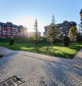 Apartment Forum III في أسّاغو: شارع مرصوف بالحصى في حديقة فيها اشجار ومباني