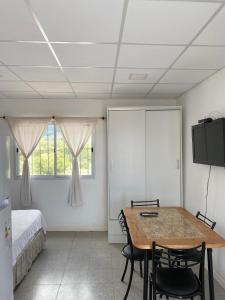 Habitación con mesa, sillas y cama en Departamento en La Punta en La Punta