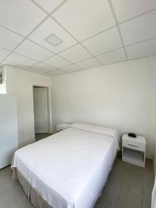 ein Schlafzimmer mit einem weißen Bett und einer weißen Decke in der Unterkunft Departamento en La Punta in La Punta