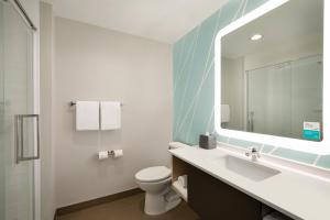 a bathroom with a sink and a toilet and a mirror at Hattiesburg West, an IHG Hotel in Hattiesburg