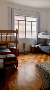 Hostel Tropeiro de Minas في جويز دي فورا: غرفة بسريرين بطابقين وأرضية خشبية