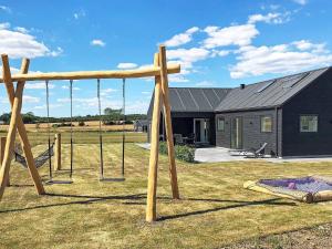 a playground with swings in a yard with a house at 10 person holiday home in Odder in Odder
