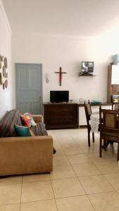 a living room with a couch and a cross on the wall at Hostel Tropeiro de Minas in Juiz de Fora