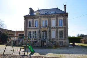 an old house with a playground in front of it at Le Betrot in Estissac