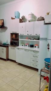 uma cozinha com armários brancos e pratos nas prateleiras em Hostel Tropeiro de Minas em Juiz de Fora