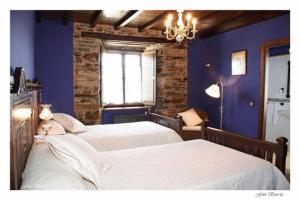 a blue bedroom with two beds and a window at Casa Rural Vila Pomar in Ribadeo