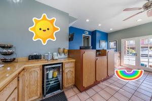 uma cozinha com um frigorífico e um sol na parede em Rodeway Inn Carson - Los Angeles South em Carson