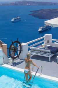 a woman in a swimming pool on a cruise ship at On The Rocks - Small Luxury Hotels of the World in Imerovigli