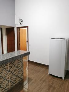 a kitchen with a counter and a refrigerator at Casa do Diogo in Capitólio