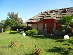 una casa con techo de paja en un patio en Cabañas Villa Lounge en San Rafael