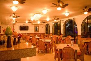 un ristorante con tavoli, sedie e ventilatori a soffitto di Hotel Chucarima a Cúcuta