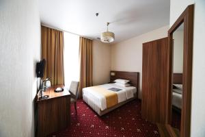 ウラジオストクにあるホテル ヴェルサイユのベッドと鏡が備わるホテルルーム