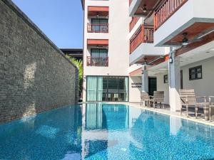 a swimming pool in front of a building at Hotel De Sripoom -SHA Extra Plus in Chiang Mai