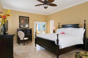 a bedroom with a bed and a ceiling fan at Windsong on the Reef in Grace Bay
