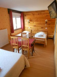 Zimmer mit 2 Betten, einem Tisch und Stühlen in der Unterkunft Hôtel L'Orée du Bois in Xonrupt-Longemer
