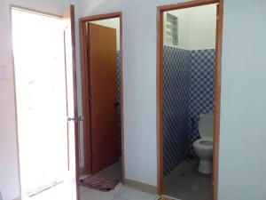 a bathroom with a toilet and two mirrors at Rosita's Cottages by the Road in Moalboal +35 photos