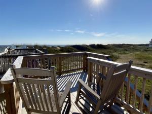 two chairs sitting on a deck looking out at the ocean at NC 12 56821-10 Condo in Hatteras +2 photos