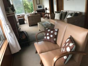 un soggiorno con divano e cuscini sopra di Summertime Cottage a Southport