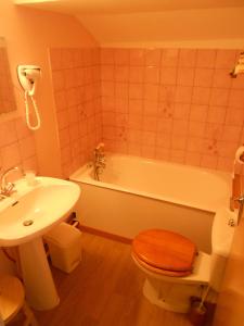 ein Badezimmer mit einer Badewanne, einem WC und einem Waschbecken in der Unterkunft Hôtel L'Orée du Bois in Xonrupt-Longemer
