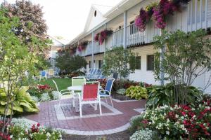 a patio with chairs and tables in a garden at Main Street Motel in Fish Creek