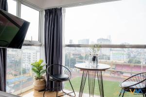 a room with a table and chairs and a large window at Libré Homestay in Hanoi